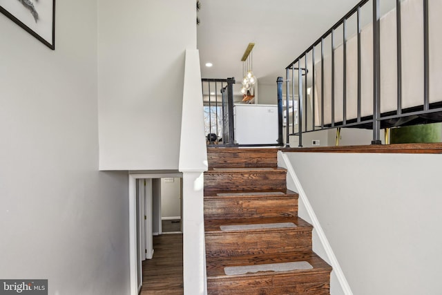 staircase with wood finished floors and baseboards