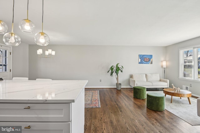 living area featuring dark wood-type flooring, visible vents, and baseboards