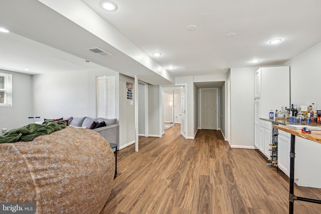 interior space featuring recessed lighting, visible vents, dark wood-style flooring, and baseboards