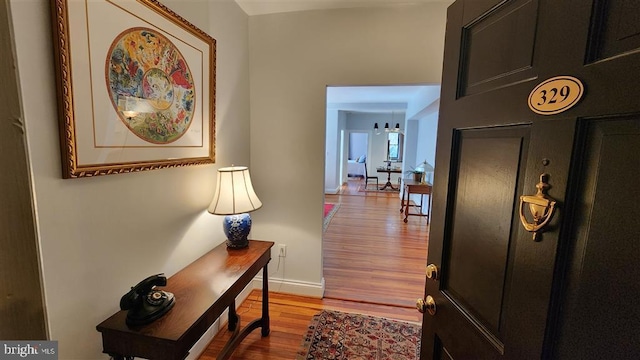 hall featuring baseboards and wood finished floors