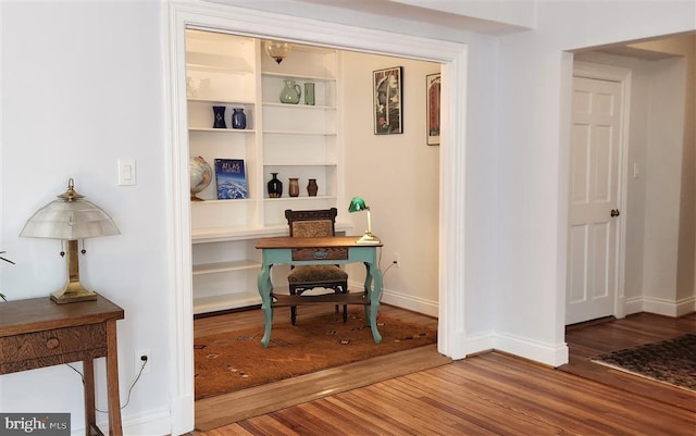 home office with baseboards and wood finished floors