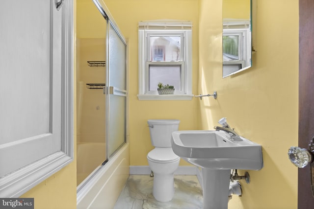 bathroom with toilet, baseboards, and enclosed tub / shower combo
