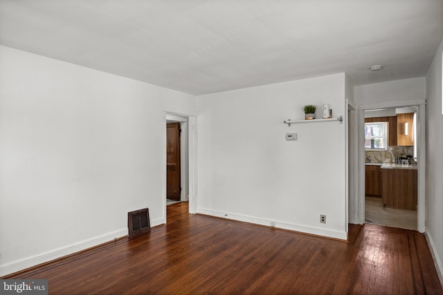 empty room featuring wood finished floors and baseboards