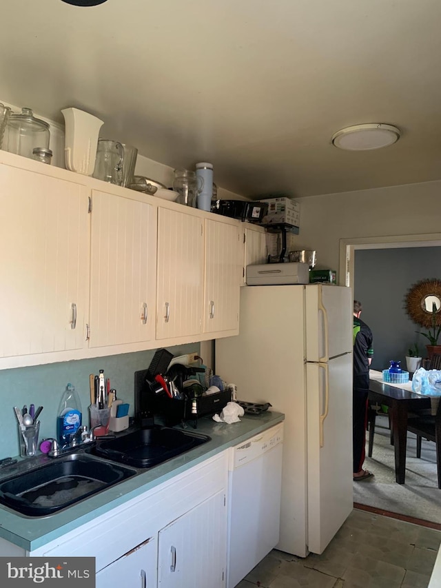 kitchen featuring white appliances and a sink