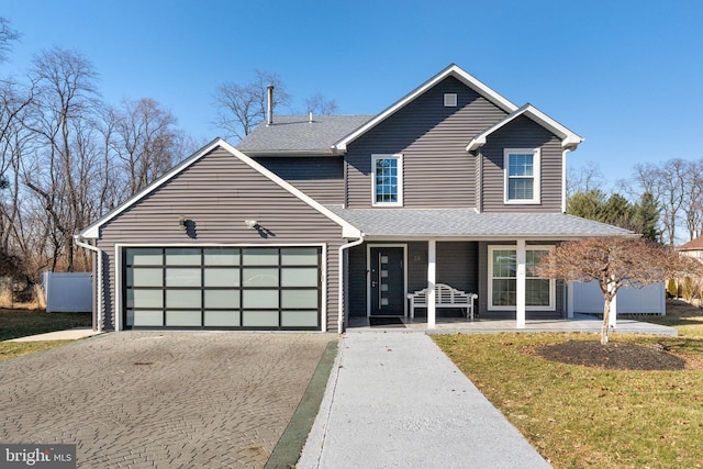 view of front of home with an attached garage, driveway, and a shingled roof