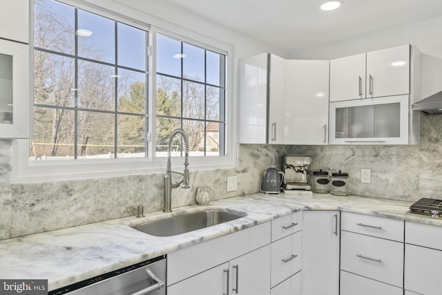 kitchen featuring a sink, decorative backsplash, glass insert cabinets, appliances with stainless steel finishes, and white cabinetry