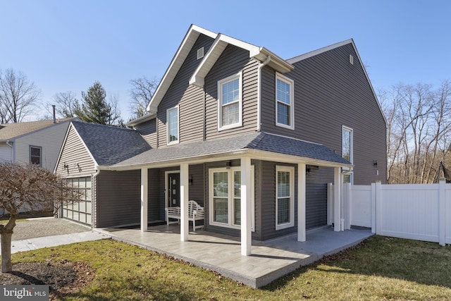 back of house with a patio, fence, a yard, a shingled roof, and a garage