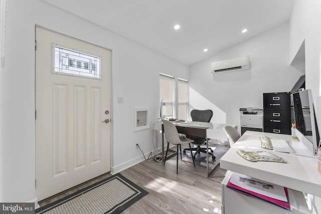 home office featuring wood finished floors, baseboards, lofted ceiling, recessed lighting, and a wall mounted air conditioner