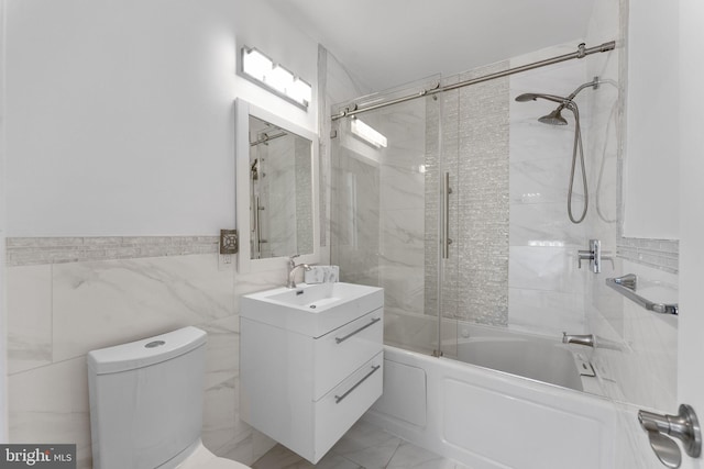 full bath featuring vanity, shower / bath combination with glass door, tile walls, toilet, and marble finish floor