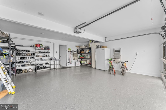 garage featuring a garage door opener and freestanding refrigerator