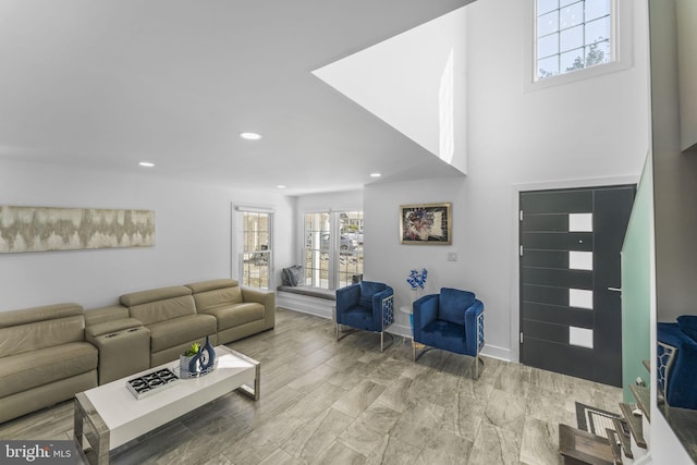 living room featuring recessed lighting, baseboards, and a healthy amount of sunlight