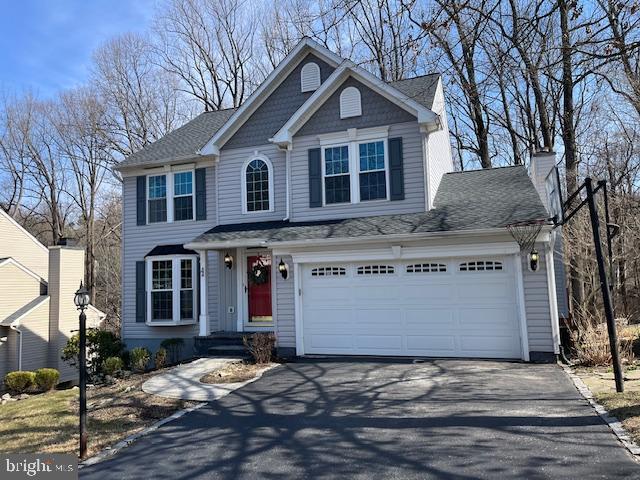 view of front of house with aphalt driveway and a shingled roof