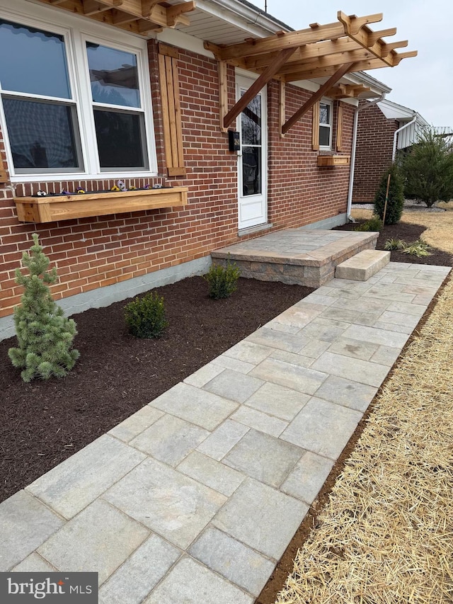 view of exterior entry featuring brick siding