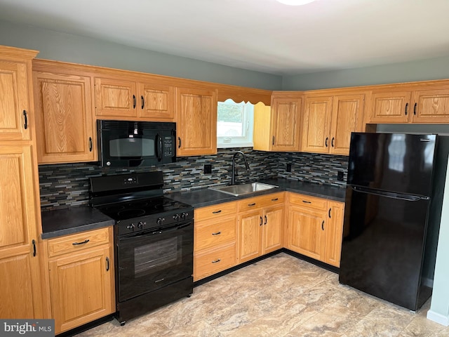 kitchen featuring a sink, tasteful backsplash, dark countertops, and black appliances