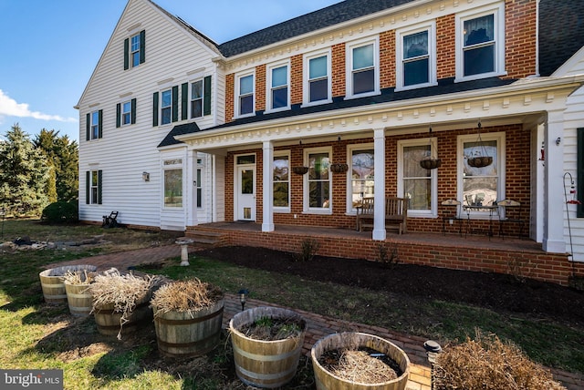 view of front of house with brick siding and a porch