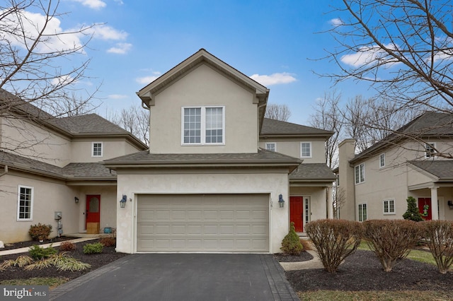 traditional home with stucco siding, a garage, and aphalt driveway