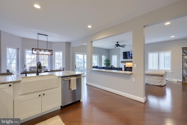 kitchen featuring recessed lighting, a fireplace, a sink, dark wood-type flooring, and stainless steel dishwasher