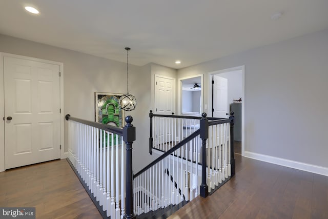 corridor featuring recessed lighting, baseboards, an upstairs landing, and dark wood finished floors