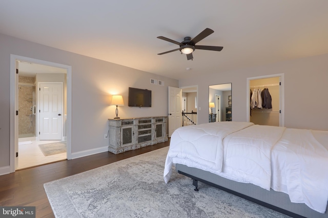 bedroom featuring visible vents, a walk in closet, ensuite bathroom, wood finished floors, and baseboards