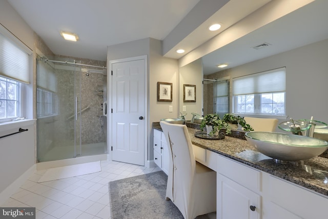 full bath with visible vents, a shower stall, tile patterned flooring, baseboards, and vanity