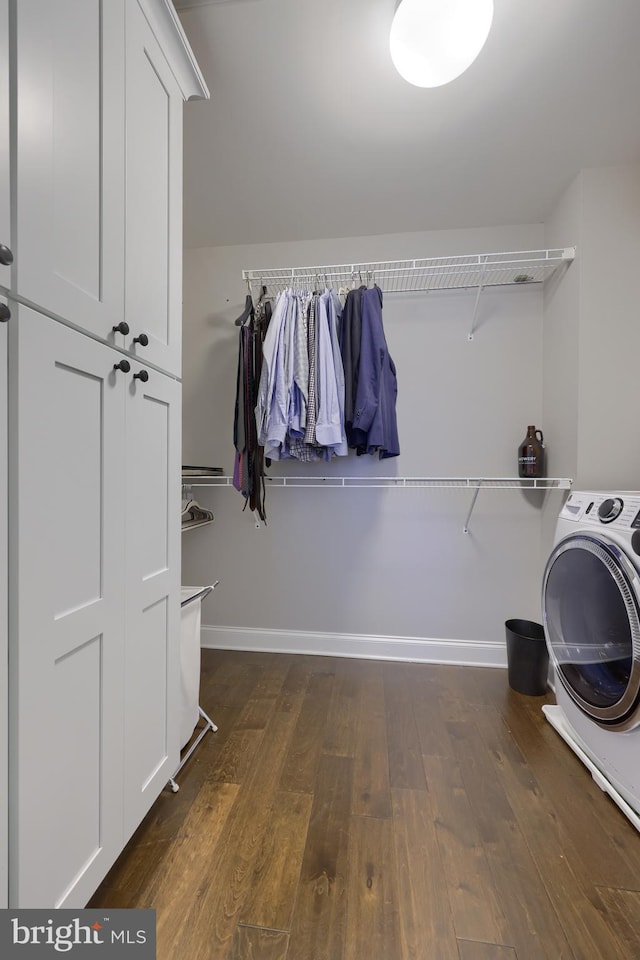 laundry area with washer / dryer, cabinet space, baseboards, and dark wood-type flooring