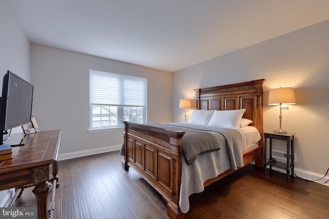 bedroom with baseboards and dark wood finished floors