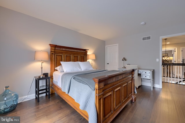 bedroom with visible vents, baseboards, a chandelier, and dark wood finished floors