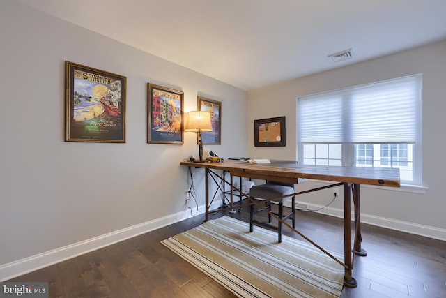 office area featuring visible vents, baseboards, and wood finished floors