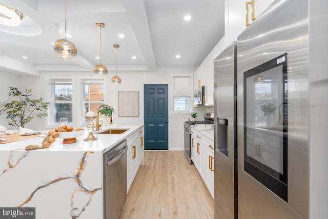 kitchen featuring light wood-type flooring, a sink, white cabinetry, recessed lighting, and appliances with stainless steel finishes