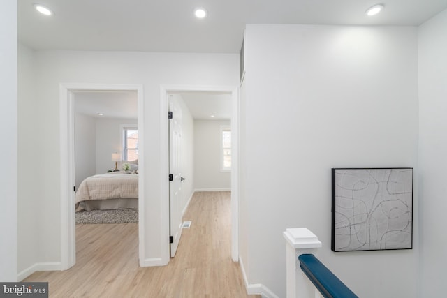 hall with recessed lighting, baseboards, and light wood finished floors