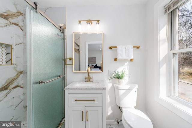 bathroom with a marble finish shower, plenty of natural light, toilet, and vanity