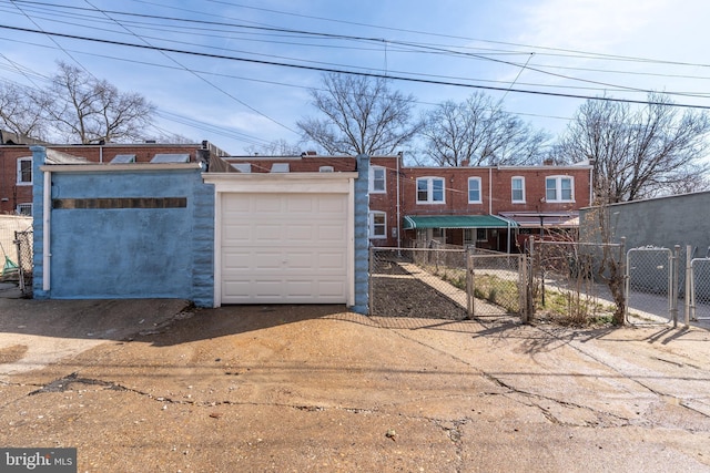 view of front of property with brick siding, driveway, fence, and a gate