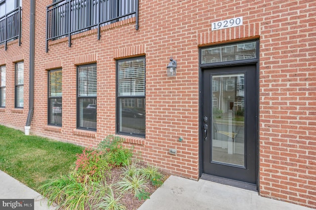 view of exterior entry featuring brick siding