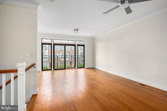 spare room with light wood-style floors, baseboards, and ornamental molding