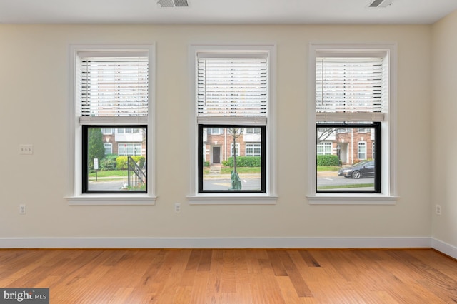 spare room with visible vents, baseboards, and light wood-style floors