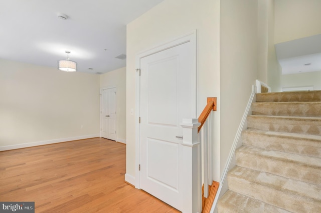 stairs with wood finished floors and baseboards