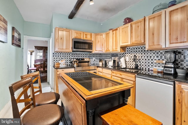 kitchen with light brown cabinetry, a sink, a kitchen island, tasteful backsplash, and appliances with stainless steel finishes