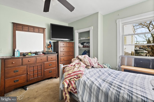 bedroom with a closet, light colored carpet, and ceiling fan