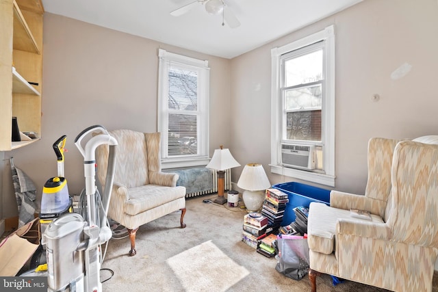 sitting room featuring cooling unit, a ceiling fan, and carpet floors