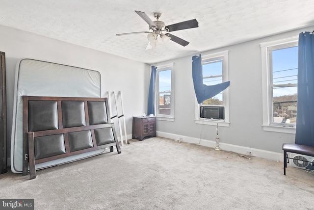 bedroom with ceiling fan, carpet, baseboards, and a textured ceiling