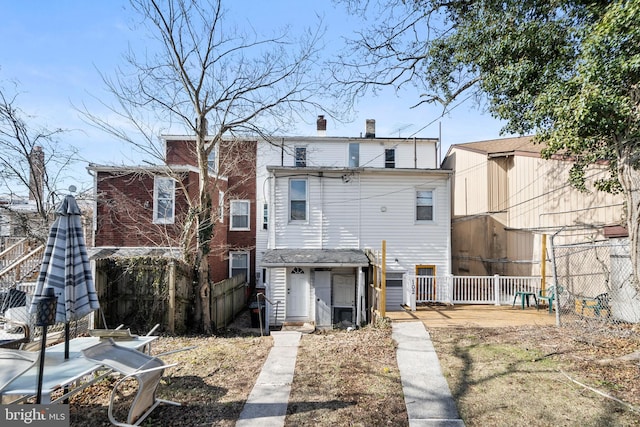 rear view of property with fence and a chimney