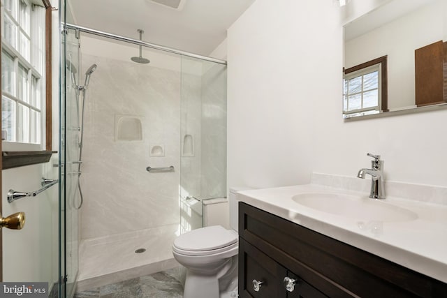 full bathroom featuring marble finish floor, a shower stall, toilet, and vanity