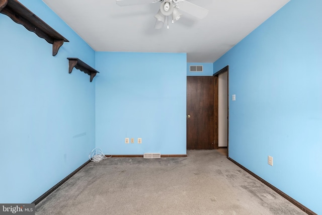 spare room featuring a ceiling fan, visible vents, carpet floors, and baseboards