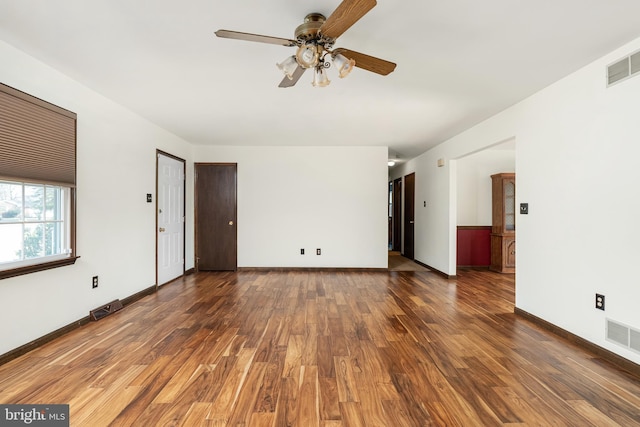 spare room featuring wood finished floors, a ceiling fan, and visible vents