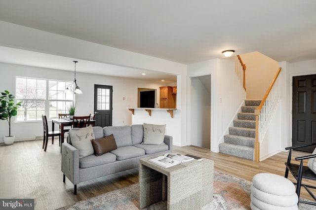 living room featuring recessed lighting, baseboards, stairs, and light wood finished floors