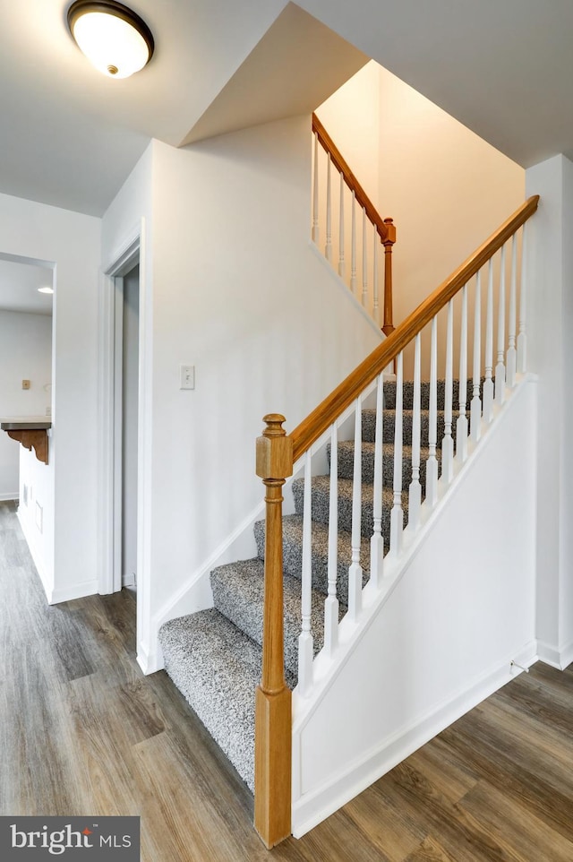 stairs with wood finished floors and baseboards