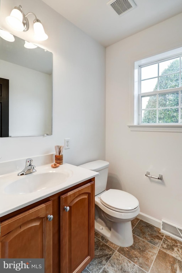 bathroom with visible vents, baseboards, toilet, and vanity