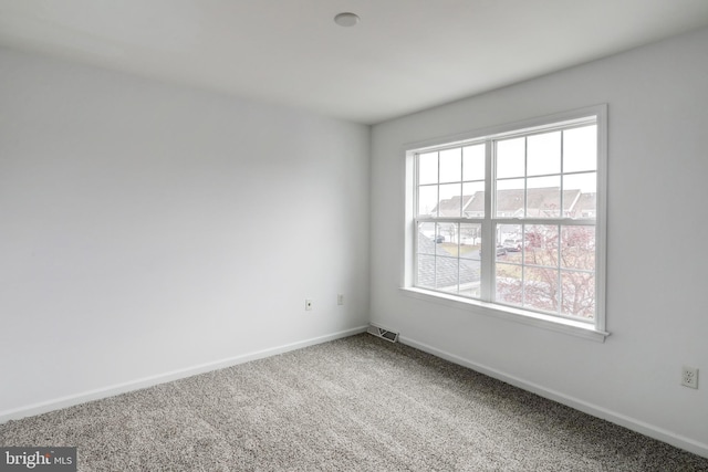 unfurnished room with visible vents, carpet floors, and baseboards