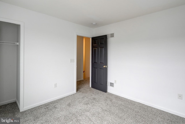 unfurnished bedroom featuring a closet, baseboards, visible vents, and carpet floors