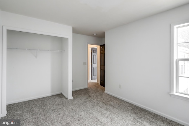 unfurnished bedroom featuring a closet, baseboards, and carpet